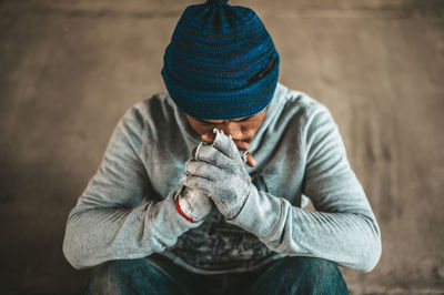 High angle view of man wearing hat sitting outdoors during winter