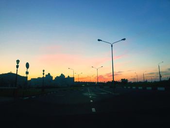 Cars on road against sky during sunset