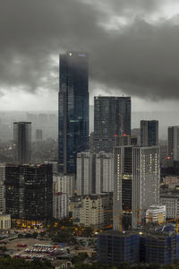 Illuminated buildings in city against sky at dusk