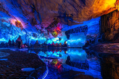 View of illuminated cave in lake