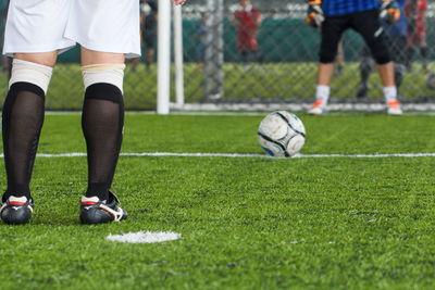 Low section of people standing on soccer field