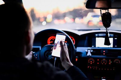 Man using phone while driving car