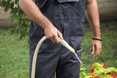 Midsection of man holding flower in field