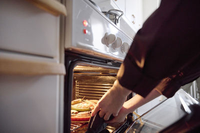 Woman taking food for eid al-fitr out of oven