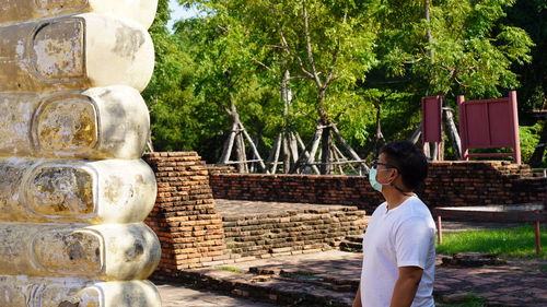 Man wearing mask looking at statue