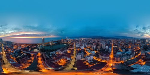 Aerial view of illuminated cityscape against sky at dusk