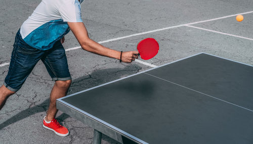 Low section of man playing table tennis