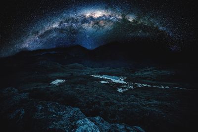 Scenic view of landscape against sky at night