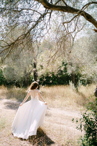 Woman standing on field by tree