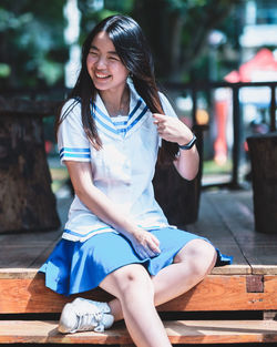 Portrait of smiling young woman sitting outdoors