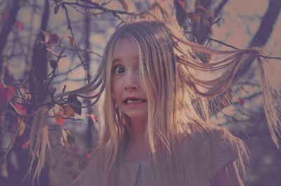 Portrait of shocked blond girl by plants