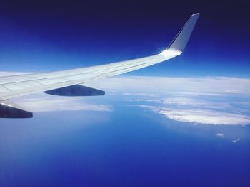 Aerial view of airplane wing against blue sky