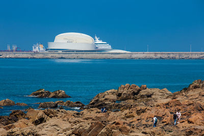 Panoramic shot of sea and rocks against clear blue sky