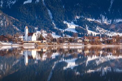 Reflection of buildings in lake during winter