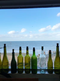 Panoramic shot of bottles in sea against sky