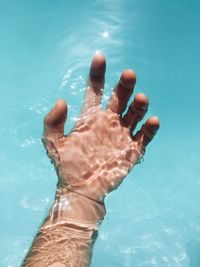 Low section of man swimming in pool