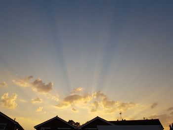 Low angle view of silhouette house against sky during sunset
