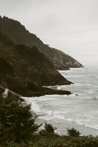 Scenic view of sea and mountains against sky