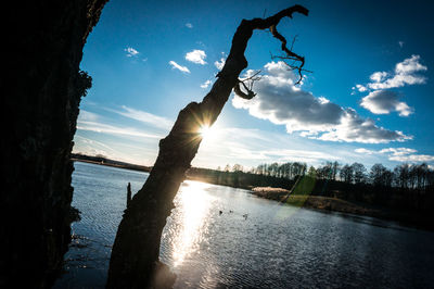 Silhouette man by lake against sky