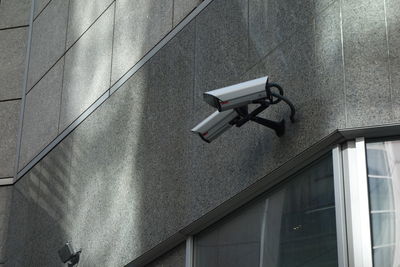 Low angle view of camera on wall of building