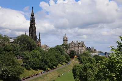 Panoramic view of buildings in city against cloudy sky