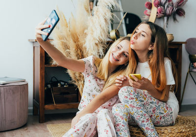 Cheerful girls doing selfie at home