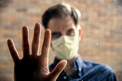 Portrait of man with hand on glass window