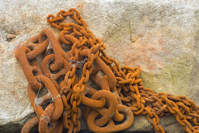 Close-up of rusty chain against wall