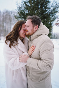 Loving couple on a snowy winter field. happy together.
