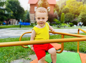 Happy toddler boy rides on a swing. indoor playground. a cute boy of one and a half years. 