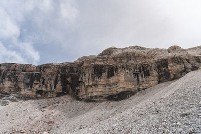 Rock formations on arid landscape against sky