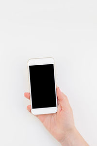 Cropped hand holding smart phone over white background