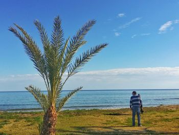 Man standing by sea against sky