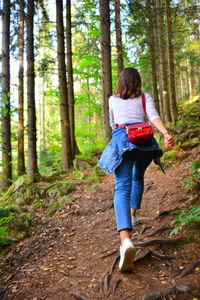 Rear view of woman walking in forest