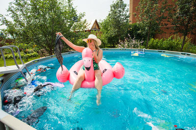 Woman jumping in swimming pool