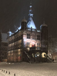 Illuminated buildings against sky during winter at night