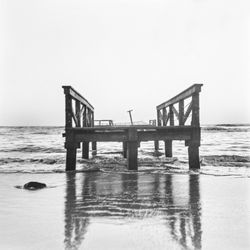 Pier over sea against clear sky