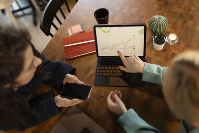 Woman showing chart on laptop screen