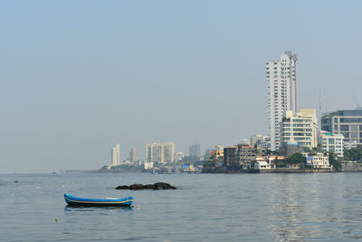 Scenic view of sea and buildings against clear sky