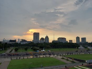 Buildings in city against cloudy sky