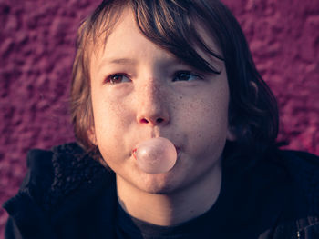 Close-up of boy blowing chewing gum