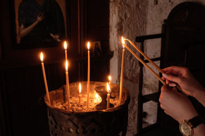 Cropped hand burning candles