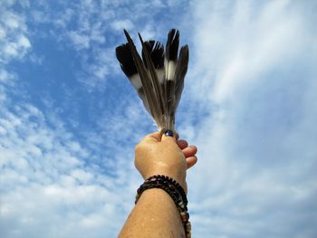 Low angle view of hand against sky