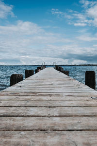 Wooden pier over sea against sky