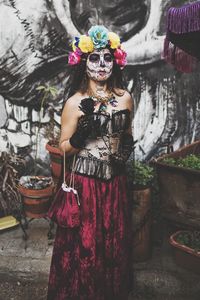 Portrait of woman standing against wall