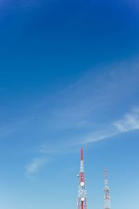 Low angle view of communications tower and building against sky