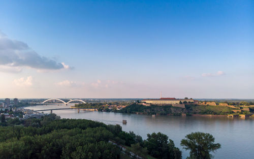 Scenic view of river by city against sky