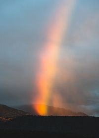 A rainbow captured at sunrise from a distance.