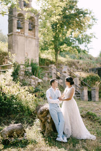 Rear view of couple holding plants