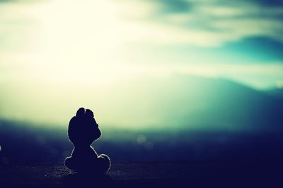 Close-up of silhouette statue against sky